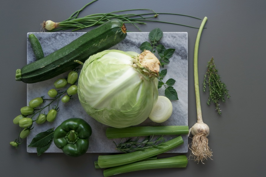 Des diverses légumes cueillis déposés sur une planchette grise dont il y a un chou mature