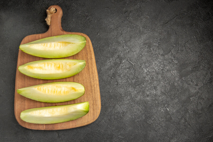 Un concombre qui a jauni vient d'être découpé sur une planchette avant de le manger