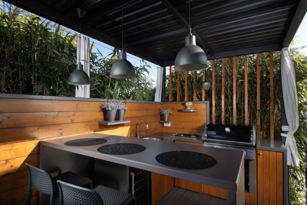 Une cuisine extérieure avec grille et des lumières
