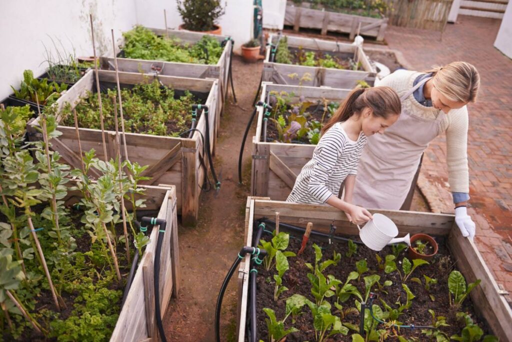 Une femme et une fille plantant des légumes au potager