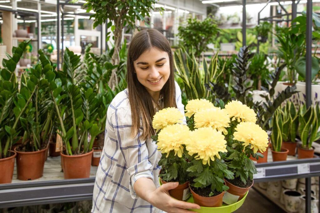 Une jeune femme tenant une plante avec des fleurs jaune