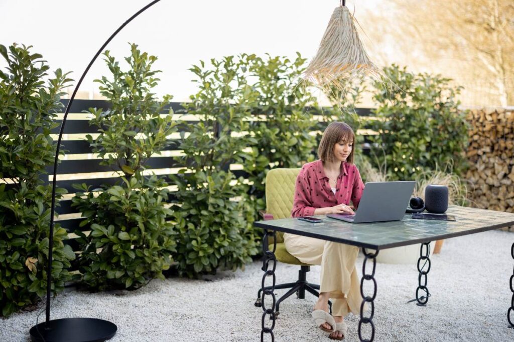 Une femme qui travaille sur un ordinateur portable dans le jardin