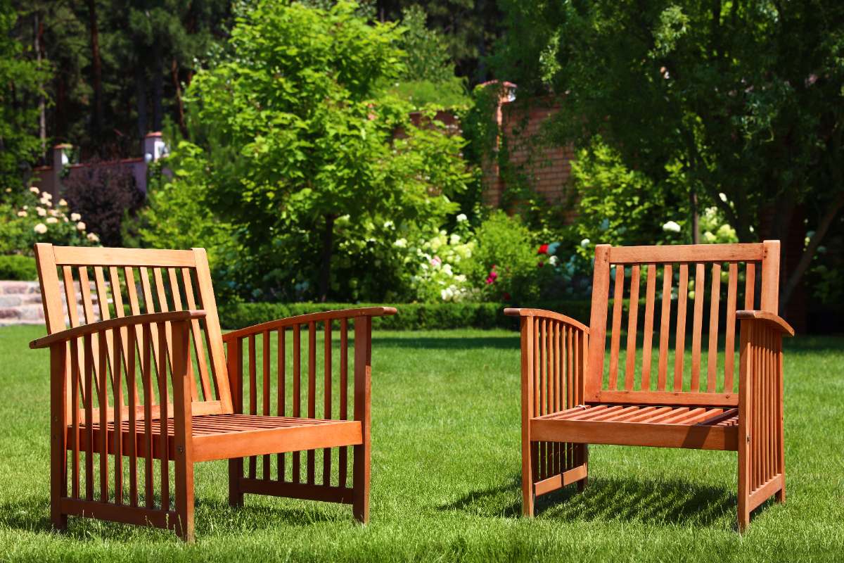 Des chaises en bois dans un jardin verdoyant
